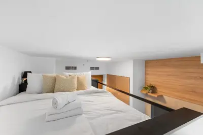 a large white bed with two towels on it at Luxe Studio Loft Type - Canal View - Fully Furnished in Dubai