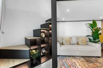 a living room with a white couch and black shelves at Luxe Studio Loft Type - Canal View - Fully Furnished in Dubai