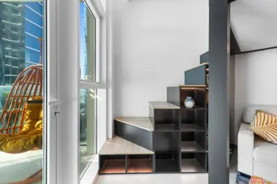a living room with a window and a desk at Loft-Style Studio - Canal View - Fully Furnished - Near Dubai Mall - Burj Khalifa in Dubai