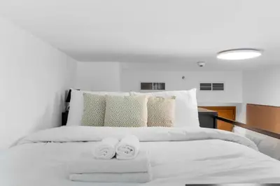 a bedroom with a white bed with towels on it at Loft-Style Studio - Canal View - Fully Furnished - Near Dubai Mall - Burj Khalifa in Dubai