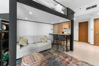 a living room with a couch and a bar at Loft-Style Studio - Canal View - Fully Furnished - Near Dubai Mall - Burj Khalifa in Dubai