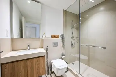 a bathroom with a shower and a toilet and a sink at DTV 2BR Burj View, Pool in Dubai