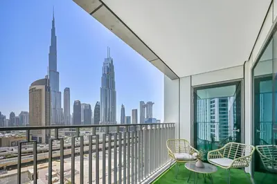 a balcony with chairs and a view of the city at DTV 2BR Burj View, Pool in Dubai