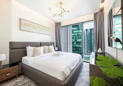 a bedroom with a large bed and a large window at Waterfront 1BR - Canal View - Fully Furnished in Dubai