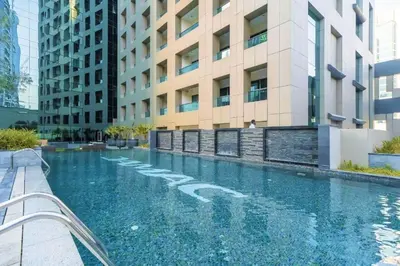 a swimming pool in front of a building at DAMAC 1BHK Apt Business Bay Dubai with Pool & Canal Walk in Dubai