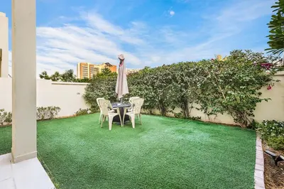 a patio with a table and chairs and an umbrella at Stylish 4BR Family Villa Easy Access to Dubai Marina & Expo City in Dubai