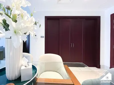 a dining room with a table with a vase of flowers at Burj Views from Balcony l Chic 2BR in Downtown in Dubai