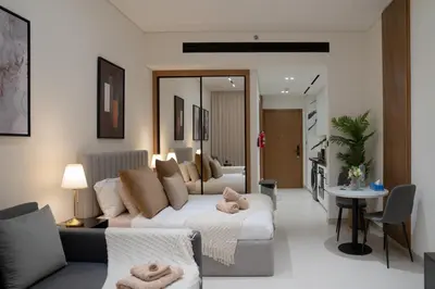 a living room with a white couch and a table at Lux Business Bay Studio with Jacuzzi & Canal View in Dubai