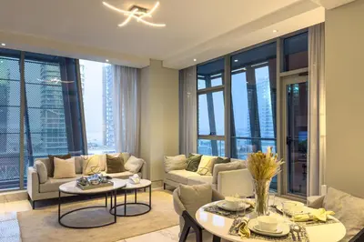 a living room with a couch and tables and windows at Modern Living with Canal Views, Near Burj Khalifa and World Trade Center in Dubai