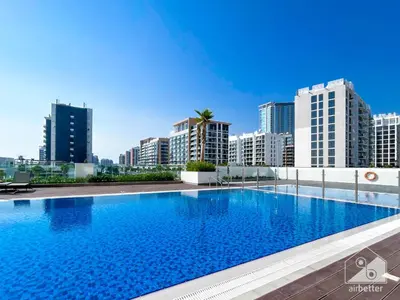 a large swimming pool in a city with tall buildings at Luxury & City Views Studio in Azizi Riviera in Dubai