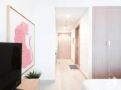 a room with a bed and a television and a hallway at Luxury & City Views Studio in Azizi Riviera in Dubai