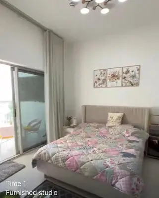 a bedroom with a bed in a room with a window at Dubailand in Dubai