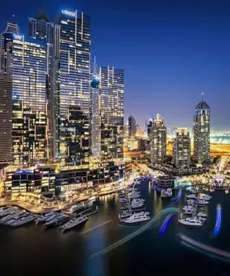 a city skyline at night with boats in the water at Luxury living , Triple pool access at Marina views in Dubai