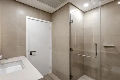 a bathroom with a shower and a sink at Luxury living , Triple pool access at Marina views in Dubai