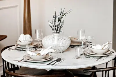 a dining room table with a vase on it at Luxury living , Triple pool access at Marina views in Dubai