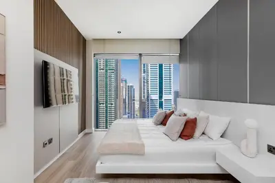 a living room with a white couch and a large window at Luxury living , Triple pool access at Marina views in Dubai