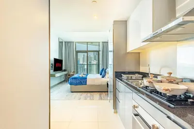 a kitchen with a view of a bedroom with a bed at Elegant Studio Business Bay - Balcony with Skyline Views in Dubai