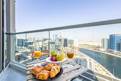 a table with bread and fruit and glasses of orange juice at Elegant Studio Business Bay - Balcony with Skyline Views in Dubai