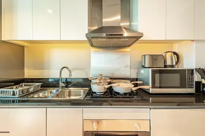 a kitchen with two pots on top of a stove at Elegant Studio Business Bay - Balcony with Skyline Views in Dubai