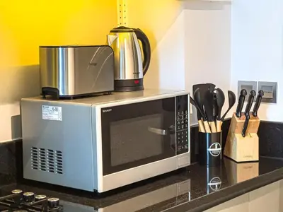a microwave sitting on top of a kitchen counter at Elegant Studio Business Bay - Balcony with Skyline Views in Dubai