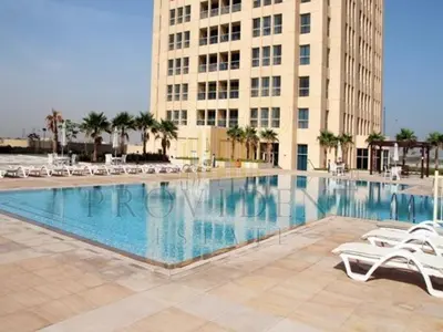 a large swimming pool in front of a building at Stylish 1BR Apt with Canal Views in Dubai