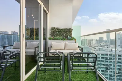 a balcony with a table and chairs and a view at Cozy 1BR Vera Tower with Amazing Burj Khalifa View in Dubai