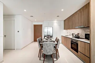 a kitchen with a table and chairs in a room at 2 BR, private beach access, sea view, Emaar beach front in Dubai
