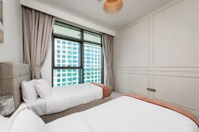 two beds in a room with a large window at 2 BR, private beach access, sea view, Emaar beach front in Dubai