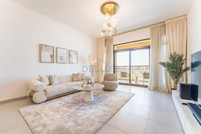 a living room with a couch and a table at Balcony Overlooking Community 2BR with Assistant Room, Minutes Away From the Beach, Madinat Jumeirah Living Rahaal 2, Jumeirah by Deluxe Holiday Homes in Dubai