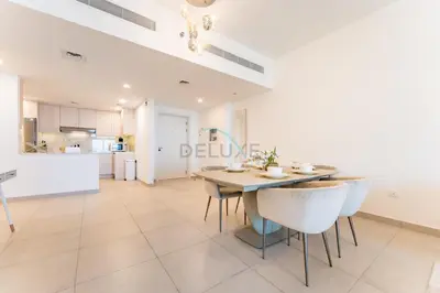 a kitchen and dining room with a table and chairs at Balcony Overlooking Community 2BR with Assistant Room, Minutes Away From the Beach, Madinat Jumeirah Living Rahaal 2, Jumeirah by Deluxe Holiday Homes in Dubai