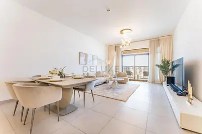 a white dining room with a table and chairs at Balcony Overlooking Community 2BR with Assistant Room, Minutes Away From the Beach, Madinat Jumeirah Living Rahaal 2, Jumeirah by Deluxe Holiday Homes in Dubai