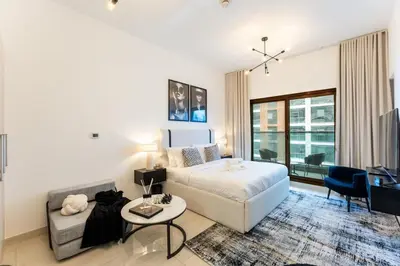 a bedroom with a bed and a couch and a table at Modern Studio in Elite Business Bay Residence in Dubai