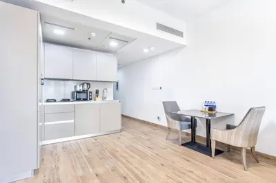 a kitchen and dining room with a table and chairs at VacayLettings - 1 BHK - Near Jebel Ali Port- IKEA - Metro 20 Min - Al Furjan in Dubai