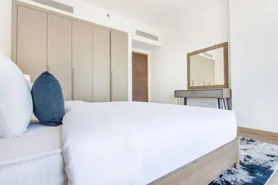a bedroom with a white bed and a mirror at VacayLettings - 1 BHK - Near Jebel Ali Port- IKEA - Metro 20 Min - Al Furjan in Dubai