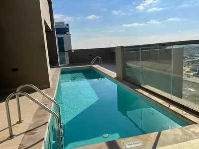 a swimming pool on the roof of a building at VacayLettings - 1 BHK - Near Jebel Ali Port- IKEA - Metro 20 Min - Al Furjan in Dubai