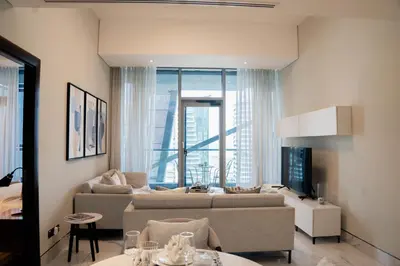 a living room with a couch and a table at Experience Modern Comforts Near Iconic Dubai Mall and Burj Khalifa in Dubai