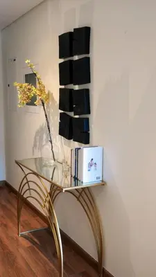 a glass table with a vase and books on a wall at Downtown Views 2 - Burj Khalifa View in Dubai