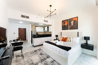 a living room with a bed and a dining room at Stunning Studio in Burj Al Nujoom in Dubai