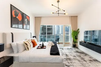 a bedroom with a large white bed and windows at Stunning Studio in Burj Al Nujoom in Dubai