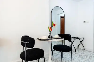 a table with chairs and a mirror in a room at Stunning Studio in Burj Al Nujoom in Dubai