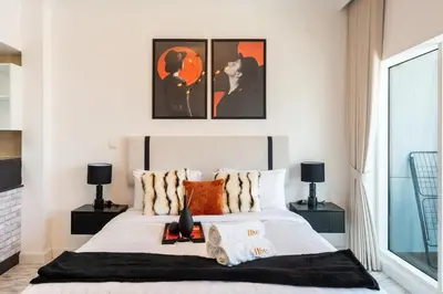 a bedroom with a bed with two pictures on the wall at Stunning Studio in Burj Al Nujoom in Dubai
