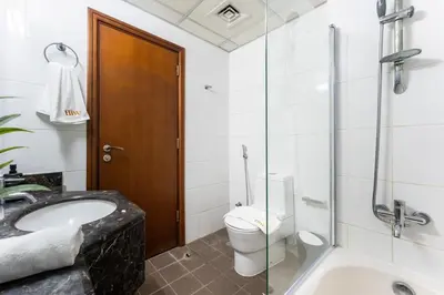 a bathroom with a toilet and a sink and a shower at Stunning Studio in Burj Al Nujoom in Dubai