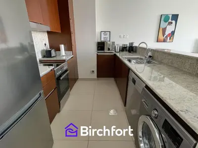 a small kitchen with a washer and dryer at Birchfort - Elegant 1BR Furnished at Mulberry in Dubai