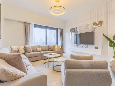 a living room with a couch and a tv at TRPS - Act One Act Two Towers, Downtown Dubai, Iconic 3BR plus Maids - with Burj Khalifa Views - Near Dubai Mall in Dubai