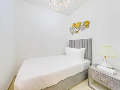 a bedroom with a bed and a table with a lamp at TRPS - Act One Act Two Towers, Downtown Dubai, Iconic 3BR plus Maids - with Burj Khalifa Views - Near Dubai Mall in Dubai