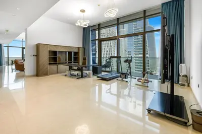 a living room with a table and a treadmill at Marina Gate 2 Penthouse Iconic Views in Dubai
