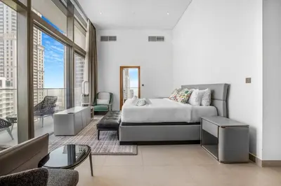 a bedroom with a bed and a living room at Marina Gate 2 Penthouse Iconic Views in Dubai