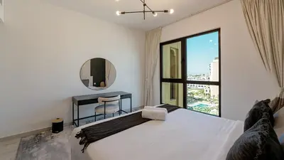 a bedroom with a bed and a table and a mirror at 1br Luxury Complex Burj AlArab View 5min to beach in Dubai