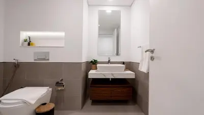 a bathroom with a sink and a toilet and a mirror at 1br Luxury Complex Burj AlArab View 5min to beach in Dubai