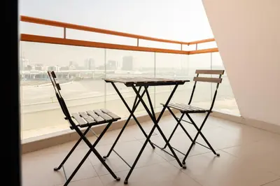 two chairs and a table in front of a window at Stylish Studio Apartment in Binghatti Crystals in Dubai